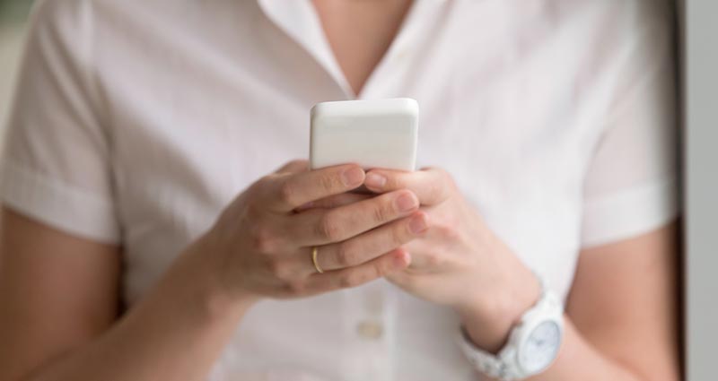 A woman browses the web on mobile phone